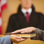 Witness swearing on the bible telling the truth in the court roo