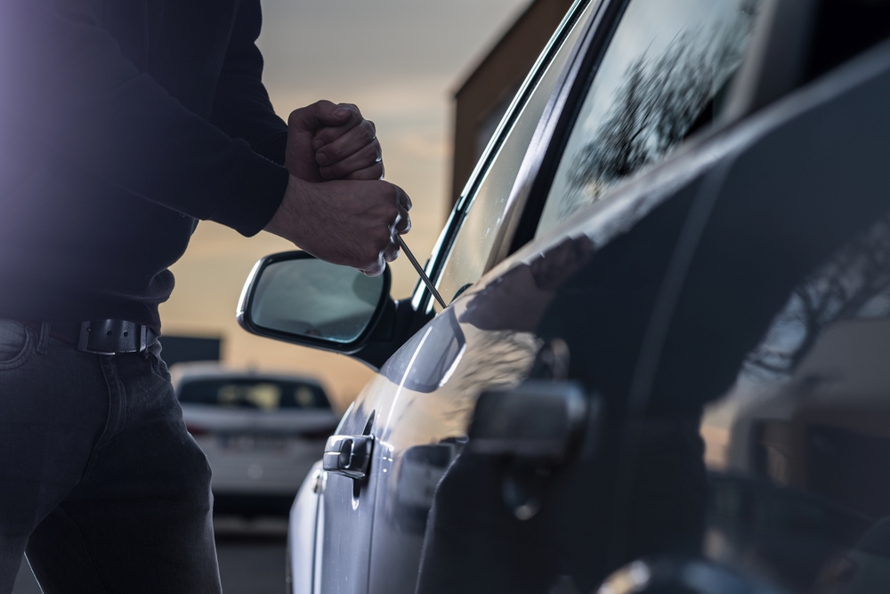 man breaking into a car