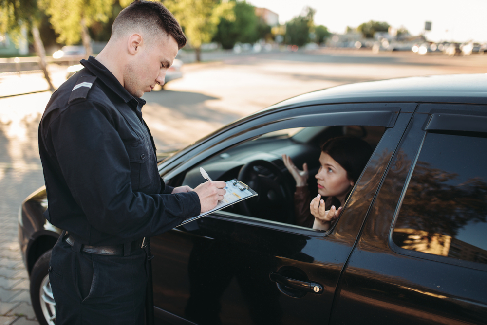 cop writing young woman a traffic ticket